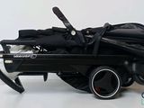 a black stroller with a black umbrella on top of it