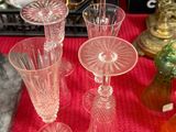 de nombreux vases en verre posés sur une table recouverte d'une nappe rouge