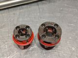 two red and black plugs sitting on a metal surface