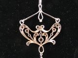 a close up of a silver necklace on a black surface