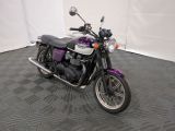 une moto violette et noire garée dans une pièce au sol carrelé