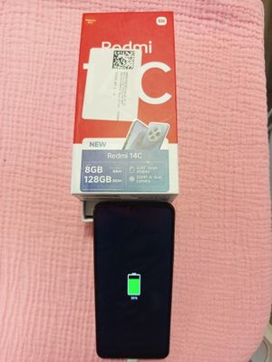une couverture rose posée sur le lit, avec un téléphone portable dedans