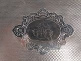 a silver plate with a picture on it on a metal surface