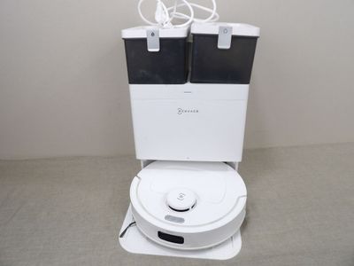 des toilettes blanches surmontées de deux poubelles noires et blanches