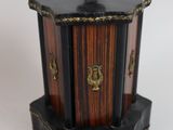 a small wooden box with a lid on a white surface