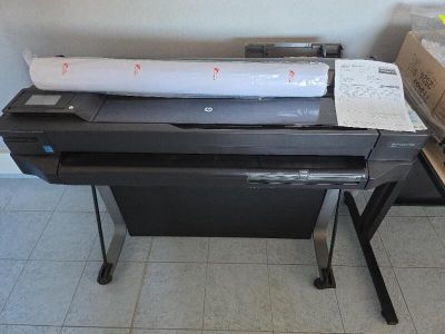 une imprimante posée sur un bureau, à côté d'une boîte de papier
