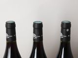 three bottles of wine sitting on top of a table next to each other