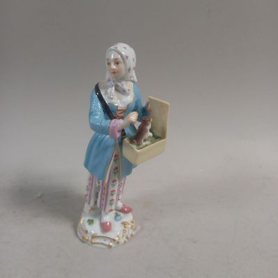 une figurine représentant une femme tenant un panier de fleurs