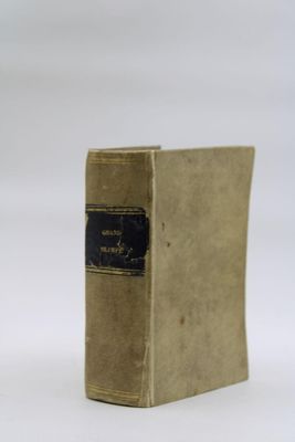 an old book sitting on top of a white table next to a white wall