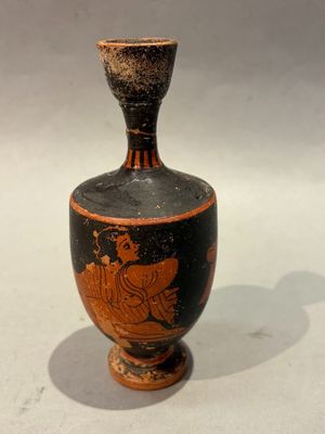 a black and red vase sitting on a white surface