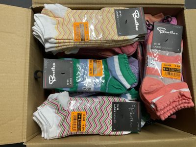 de nombreuses paires de chaussettes dans une boîte posée sur une table