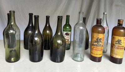 Des bouteilles de différentes tailles et couleurs sont alignées sur une table