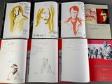 six books with drawings of people on them sitting on top of a table