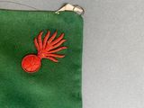 a green pouch with a red object on it