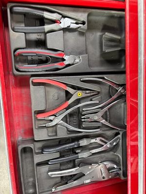 de nombreux outils dans une boîte à outils rouge posée par terre