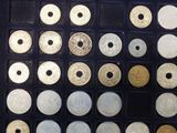 many different types of coins in a display case