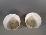 two empty cups sitting next to each other on a table