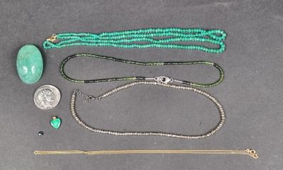 Plusieurs bijoux sont disposés sur une surface grise