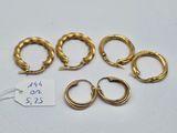 four pairs of gold hoop earrings and a price tag on a white surface