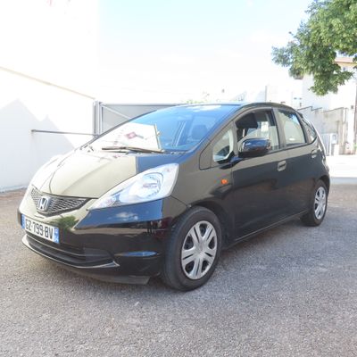 la photo d'une petite voiture noire garée dans un parking