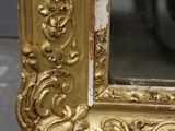a picture of a gold framed mirror on the floor