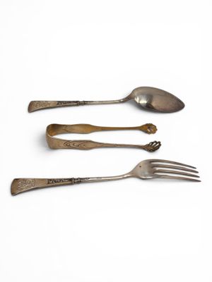 three spoons and a fork on a white surface