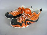 pair of orange and black sneakers with white laces on a white surface