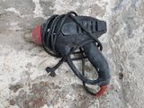 a black object on a rock with a red handle