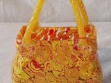 sac à main orange et jaune avec des anses, sur fond blanc