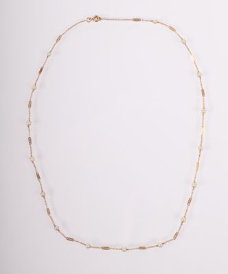 un collier à chaîne en or composé d'un long maillon et d'une petite perle