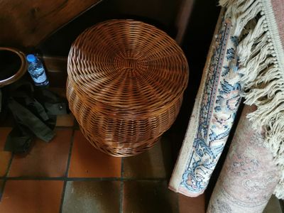 a wicker basket sitting on the floor next to a rug