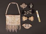 a purse, hair comb, hair clips, and other items laid out on a table