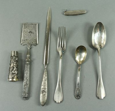 de nombreuses cuillères, fourchettes et un couteau en argent posés sur une table