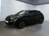 La voiture noire est garée dans une grande pièce aux murs blancs.