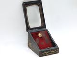 a small wooden box with a ring inside of it