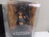 a plastic figure of a woman in a black outfit in a box