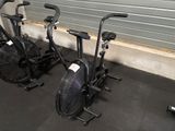 two exercise bikes that are parked next to each other