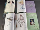 four books with drawings of women in hats and dresses on a table