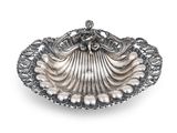 un plat en forme de coquillage argenté, orné de perles sur fond blanc