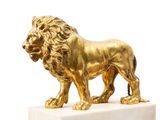 statue of a golden lion on a marble base on a white background