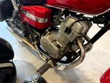 a red motorcycle parked in a showroom with a checkered floor