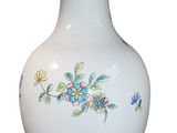 a white vase with a floral design on it