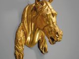 une tête de cheval en or accrochée au mur
