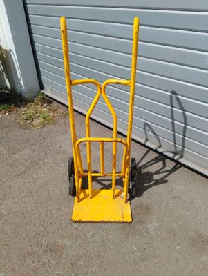 a yellow hand truck that is parked in front of a garage