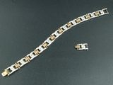 un bracelet en argent et en or et une montre posés sur une table