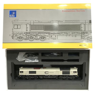 une boîte contenant un train miniature, posée sur une surface blanche