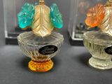 three glass vases that have different colored flowers on them