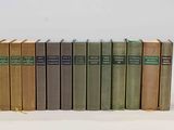 several books are stacked on top of each other on a white surface
