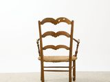 an old wooden chair sitting on top of a floor next to a white wall