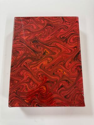 a red and black book with a swirl pattern on it